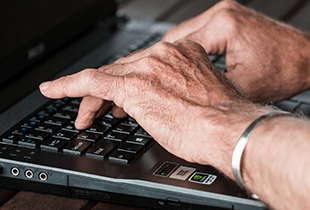 A man typing on a laptop.