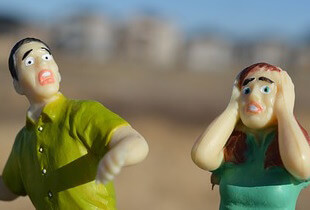 Two plastic figures looking frightened.