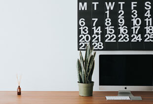 Calendar, laptop, and desk.