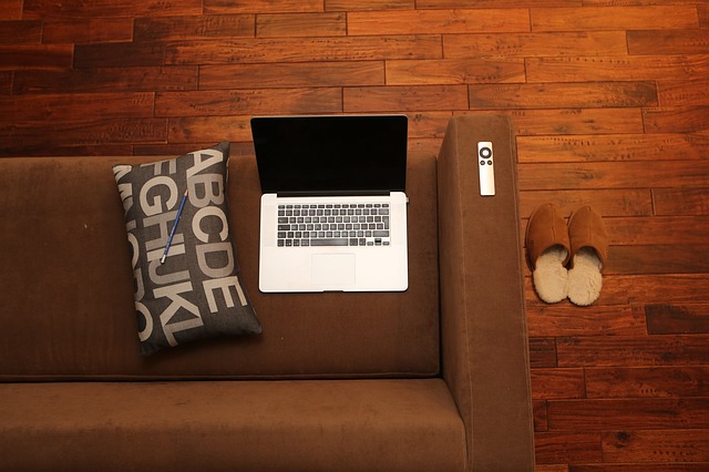 A laptop on top of a sofa.