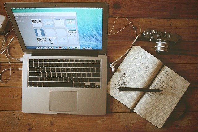 A notebook open next to a laptop.
